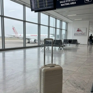 une grande valise tittou de couleur blanc cassé