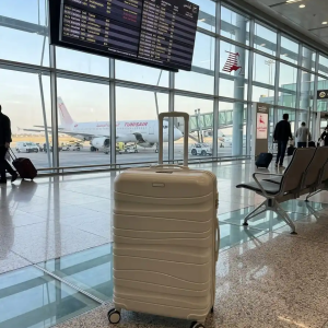 une petite valise tittou de couleur blanc cassé